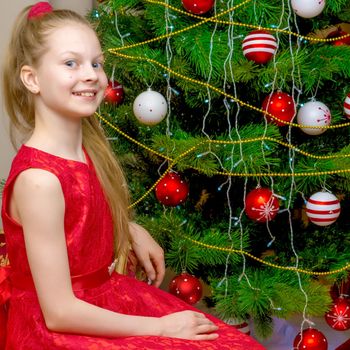 A little girl at the New Year's, Christmas tree.The concept of a holiday, happiness, a child, family well-being, Happy childhood.