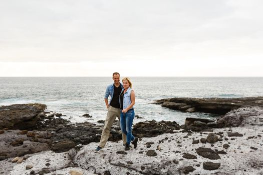 Romantic couple on the beach in a colorful sunset in the background. A guy and a girl at sunset on the island of Tenerife.