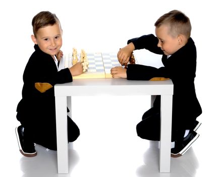 Two brothers are playing chess at home. Game, education, lifestyle concept.Isolated on white background