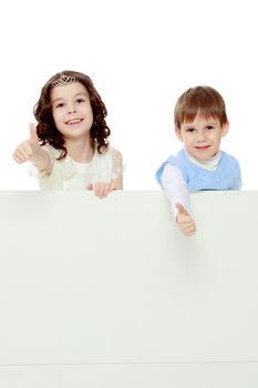 A boy and a girl peeping from behind the white banner.Children show a gesture all okay.Isolated on white background.