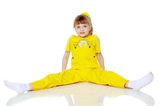 Girl with a short bangs on her head and bright yellow overalls.She crouched down on the white advertising banner.