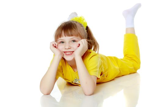 Girl with a short bangs on her head and bright yellow overalls.She crouched down on the white advertising banner.