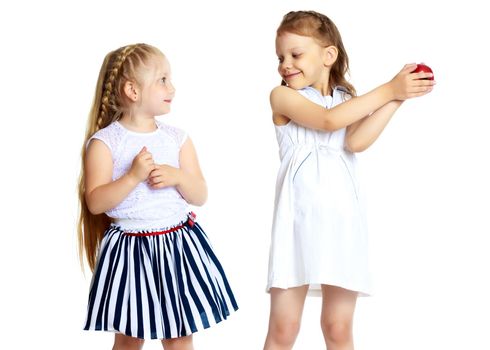 Two cute little girls with apples, in the studio on a white background. Concept of happy childhood, healthy eating. Isolated.