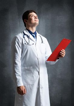 Doctor with tablet for documents, scans documents against the background of the wall