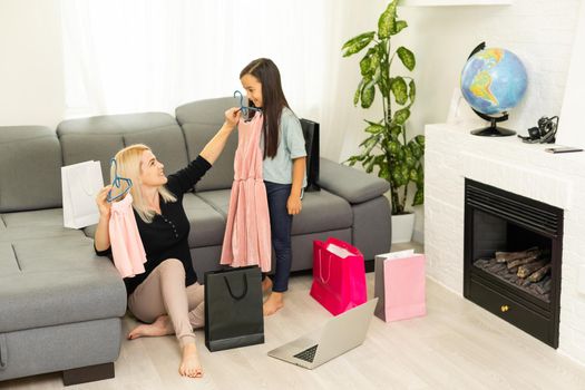 Happy Mother and daughter unpacking shopping bags in the living-room