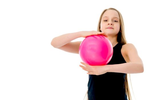 A charming little girl is engaged in fitness with a ball. The concept of gymnastics, health and sports. Isolated on white background.