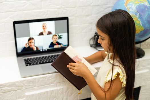 cheerful young little girl children using laptop computer, studying through online e-learning system