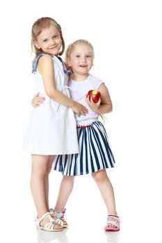 Two cute little girls with apples, in the studio on a white background. Concept of happy childhood, healthy eating. Isolated.