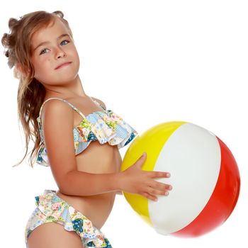 A little girl in a swimsuit is playing with a big ball. The concept of a family vacation at sea, happy childhood.Isolated on white background.