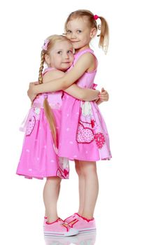 Two cute little girls in full growth, in the studio on a white background. The concept of a happy childhood, Beauty and fashion. Isolated.