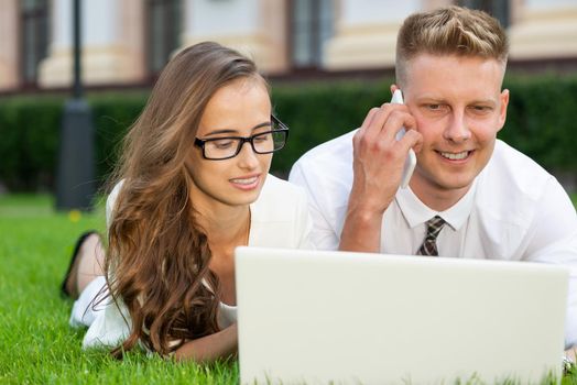 close-up portrait of businessmen in the park with a laptop. create a project together