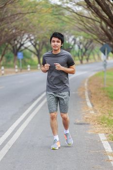 young fitness man running in the park