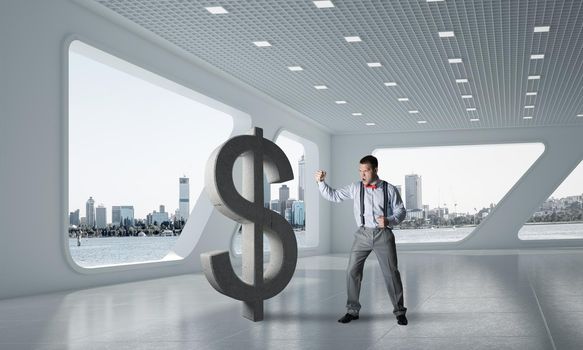 Young furious businessman going to crash with fist stone dollar symbol