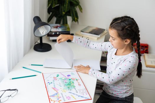 cute happy little girl writing something in her notebook