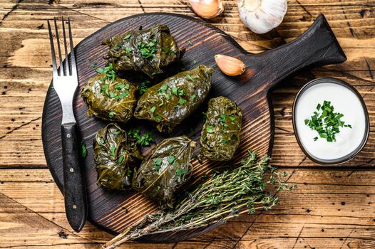 Traditional georgian dolma in grape leaves. wooden background. Top view.