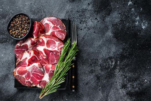 Coppa, Capocollo, Capicollo Cured ham on marble board. Black background. Top view. Copy space.