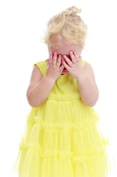 Sad girl in the yellow dress hides his face.Isolated on white background.