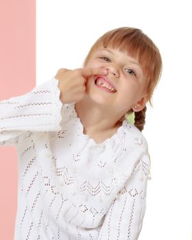 A good girl shows her finger so that she does not have a tooth. The concept of oral care. Isolated on white background.