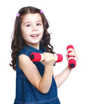 Charming girl in jeans dress holding a dumbbell.Isolated on white background portrait.