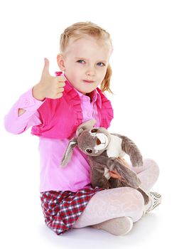 Little girl sitting on the floor go in the hands of a toy, isolated on white background.