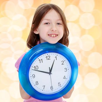 Cheerful girl holding a big round clock.