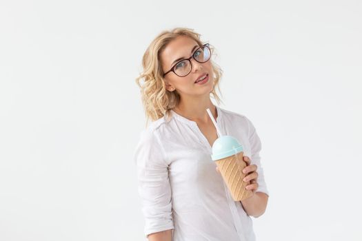 Portrait of pretty young woman is drinking smoothie over white background.