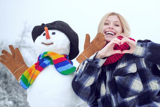 Winter woman. Happy smiling girl make snowman on sunny winter day. Winter emotion