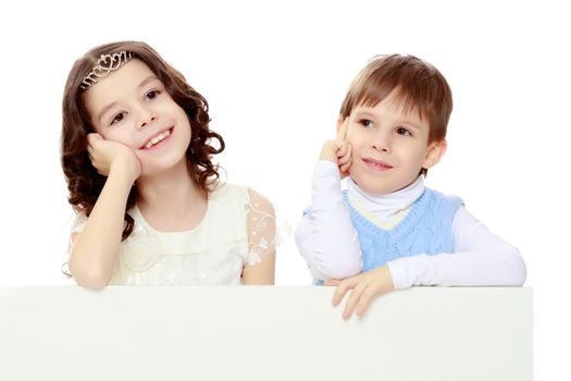 A boy and a girl peeping from behind the white banner.The children look directly into the camera.Isolated on white background.