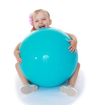 Laughing little girl hugging a big ball for fitness.Isolated on white background .