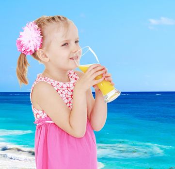 Happy little girl drinking a large glass of orange juice.