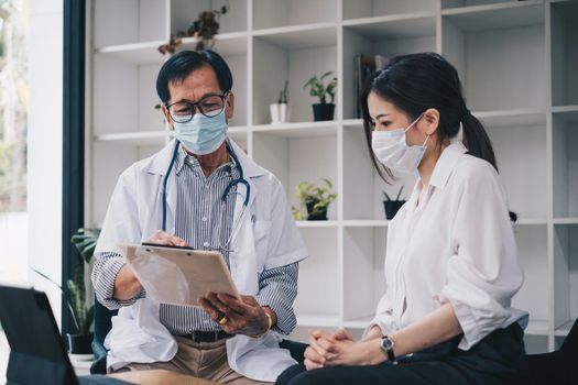 A woman with mask seeks medical advice about her health and future plans. Doctor with mask explain Healthcare and medical concept