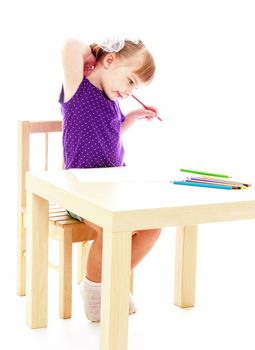 Happy childhood, adolescence, the development of the family concept.Little girl draws pencils sitting at the table. Isolated on white background.