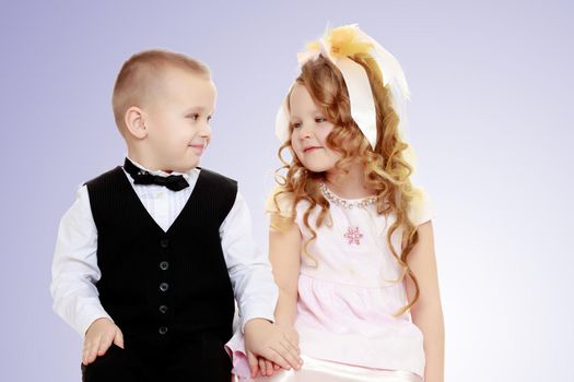 Cute little boy and girl holding hands.Purple gradient background.