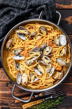 Clams vongole Seafood pasta Spaghetti in a pan. Dark Wooden background. Top view.