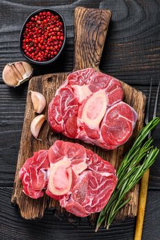 Raw meat osso buco veal shank steak , making italian ossobuco. Black Wooden background. Top view.