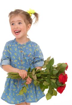 Charming little girl holding a bouquet of red roses