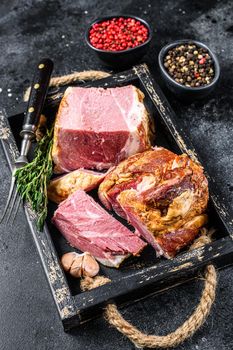 Smoked Sliced Pork Slab Bacon Meat in a wooden tray. Black background. Top view.