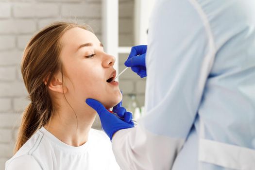 Doctor taking a throat swab from a patient to test for possible coronavirus infection