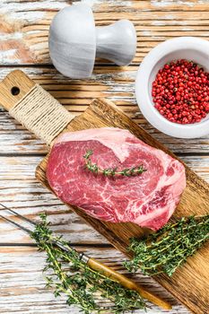 Raw beef meat Club or striploin on the bone steak. White wooden background. Top view. Copy space.