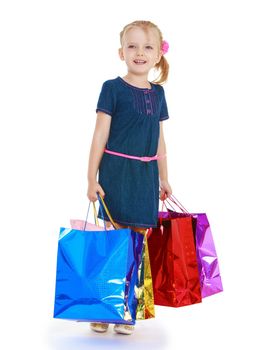 Cheerful girl with colored bags which are gifts. Isolated on white background .