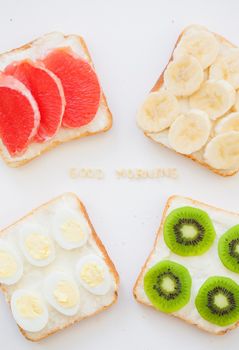 bright mix of sandwiches for breakfast fruit, vegetables, fish, eggs inscription good morning