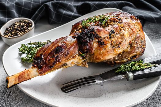 Baked goat leg with herbs. Farm meat. Gray background. Top view.