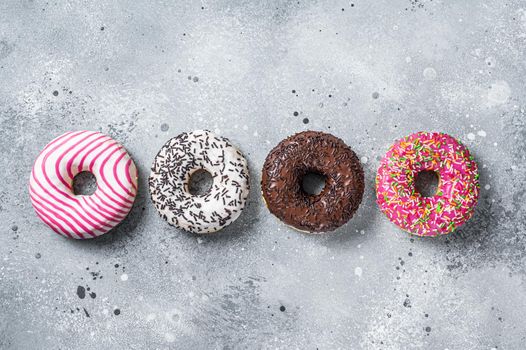 Assorted glazed donuts on a kitchen table. Gray background. Top view.