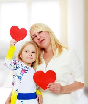 Cute little girl and her mother holding the heart.