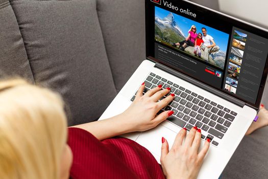 Woman watching videos online on laptop.