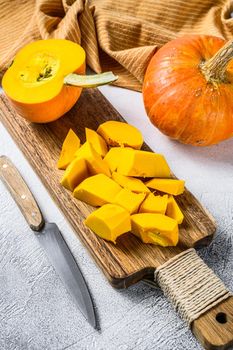 Sliced raw orange pumpkin on a chopping Board. White background. Top view.