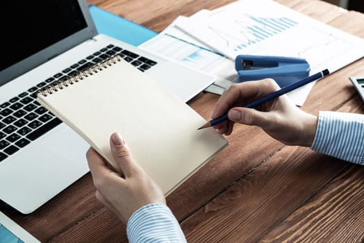 close-up, female hands with notebook and pencil. Business woman working at the table in the office