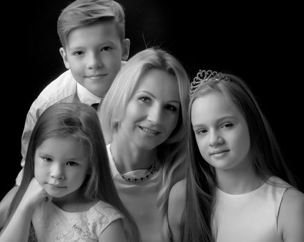 Big happy family with children on a black background. Concepts people, holidays, happiness, harmonious development of the child in the family.Black and white photo.