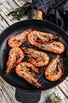 Fried giant tiger shrimps Prawns in a pan. White wooden background. Top view.