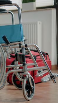 Nobody in nursing home room with transportation support for handicapped patients. Empty space with wheelchair and walk frame for medical assistance, healthcare and rehabilitation